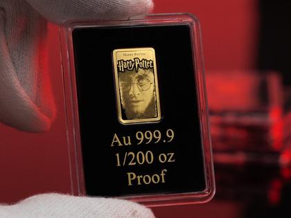 Harry Potter Goldbarren wird vor einem roten Hintergrund gehalten